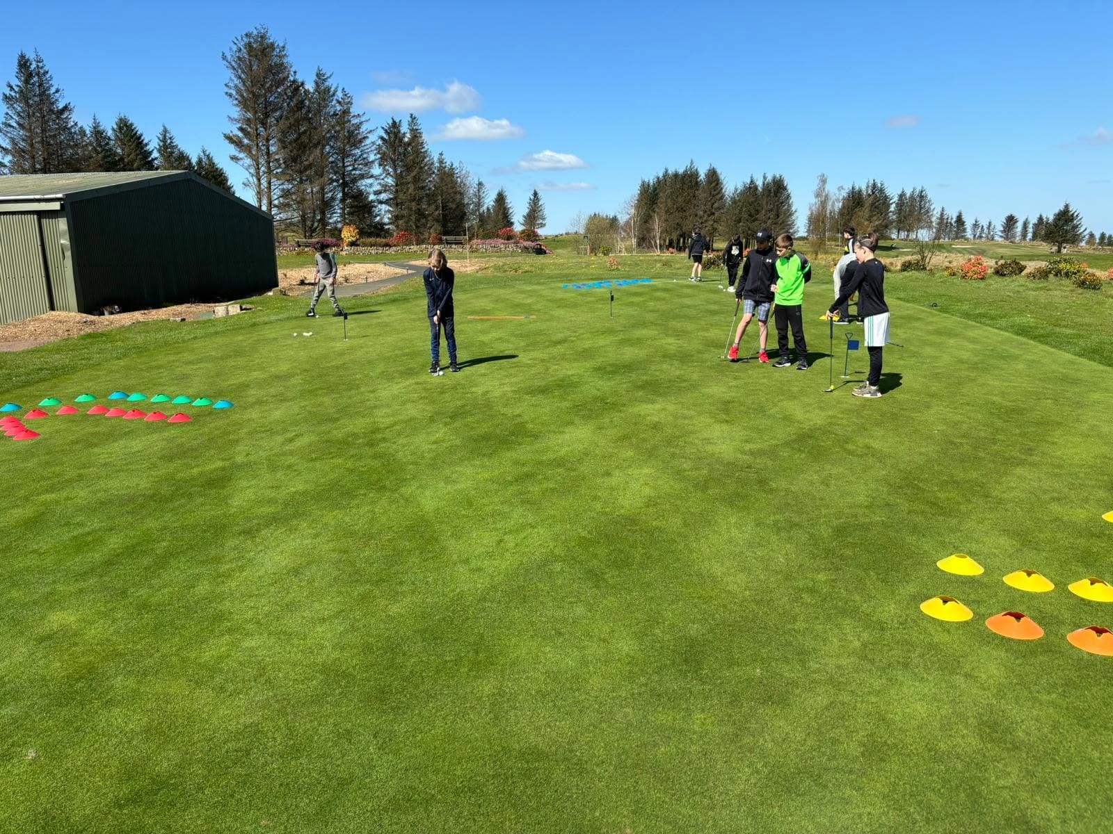 Junior golfers practising their putting on the practice green at Bonnyton